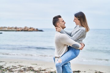 Wall Mural - Man and woman couple hugging each other holding on arms at seaside