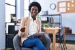 © Krakenimages.com - Young african american woman business worker writing on paperwork sitting on chair at office