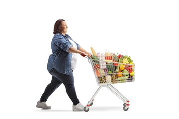 Canvas Print - Full rofile shot of an overweight woman pushing a full shopping cart