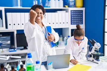 Sticker - Mother and young daughter working at scientist laboratory annoyed and frustrated shouting with anger, yelling crazy with anger and hand raised