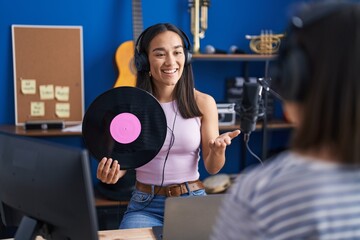 Wall Mural - Two women musicians listening to music holding vinyl disc at music studio