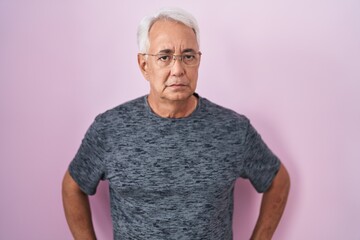 Wall Mural - Middle age man with grey hair standing over pink background skeptic and nervous, frowning upset because of problem. negative person.