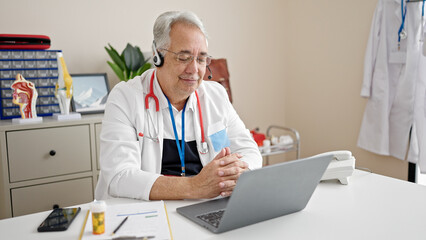 Poster - Middle age man with grey hair doctor doing online appointment at clinic