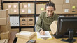 © Krakenimages.com - Young hispanic man ecommerce business worker writing on paper checking package at office