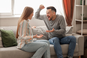 Wall Mural - Angry young couple quarreling at home. Domestic violence concept