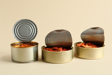 Wall Mural - Opened tin cans with fish in tomato sauce on beige background