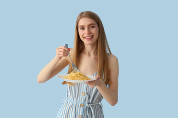 Wall Mural - Young woman with tasty pasta on blue background