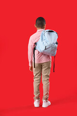 Sticker - Little African-American schoolboy with backpack on red background, back view