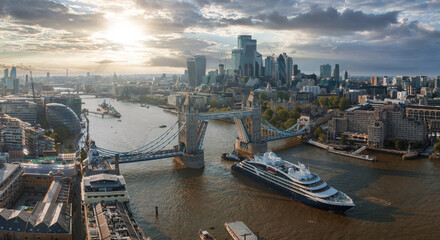 Wall Mural - Large cruise ship going through London under the Tower Bridge. Visiting center of London. Tower bridge lifting up to let the ship enter London city center.