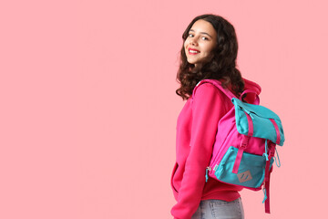 Female student with backpack on pink background