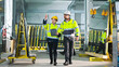 © ihorvsn - Male and female colleagues talking and planning work whilw walking at production factory. Work with folder of plan and documents at manufactoring. Production co-working. Discussion of specialists.