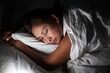© sittinan - young woman sleeping on side in her bed at night. Beautiful girl sleeping with closed eyes.