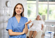 © JackF - Positive confident female doctor with stethoscope standing while elderly patient laying on exam table.