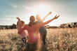 © kieferpix - Joyful family morning in the countryside, mother and children raise arms in a field with feelings of happiness and togetherness.