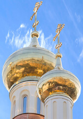 city is reflected in the new golden domes of the church on a sunny day