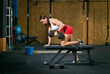 © ADDICTIVE STOCK - Positive athlete exercising on bench with dumbbell