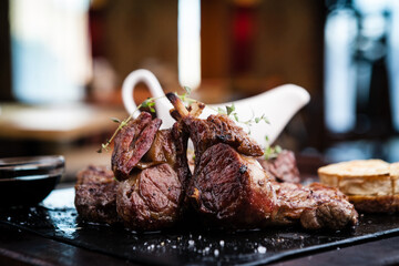 Mixed grilled meat platter. Assorted delicious grilled steaks served with goat cheese on warm dish.