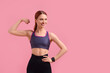 Young woman in sportswear showing muscles on pink background, space for text