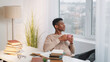 © golubovy - Coffee break. Morning ritual. Study relax. Dreamy peaceful young man drinking cup of hot tea enjoying leisure home window view at desk with books.