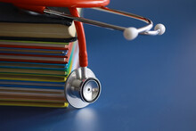 Stethoscope On Stack Of Medical Guide Book For Doctor Learning Treatment At Hospital.