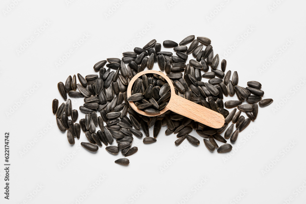 Scoop with natural sunflower seeds on white background
