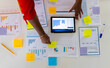 © Wavebreak Media - Hands of biracial casual businesswoman working with notes and documents using tablet in office