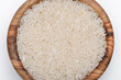 Ziarna ryżu białego ułożone w misce z drewna oliwnego na białym tle