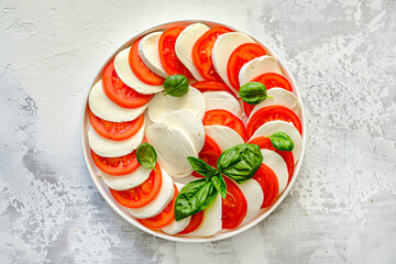 Delicious tomatoes with mozzarella and basil on a plate