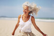 AI generated image of happy dancing mature woman at the beach