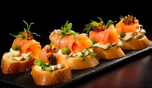 Delicious Canapés Topped With Cheese And Smoked Salmon. Dish Of Delicious Crostini With Smoked Salmon, Courgette And Cheese, Italian Appetizers.
