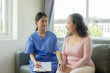 © ArLawKa - Young Asian nurse caregiver with 60 year old Asian woman giving advice and encouragement Take a history and recommend appropriate treatment to live happily in retirement in the clinic.