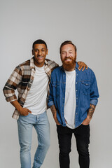 Two multinational male friends smiling and posing at camera