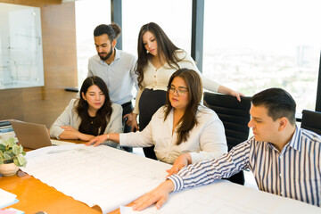 Wall Mural - Diverse group of architects working on building plan in meeting room