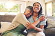 © Azee/peopleimages.com - Senior mother, funny and hug woman in living room, bonding and laughing together. Happy, elderly mom and embrace person, relax and smile with care, love and enjoying time on home sofa with family.