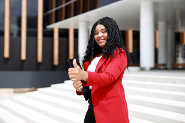 Wall Mural - happy african american businesswoman in red jacket with hand gesture