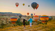 © Fokke Baarssen - Kapadokya Cappadocia Turkey, a happy young couple during sunrise watching the hot air balloons of Kapadokya Cappadocia Turkey during vacation