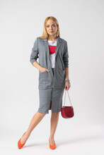 Blonde Woman In Elegant Casual Plaid Office Clothes With A Handbag On A Chain