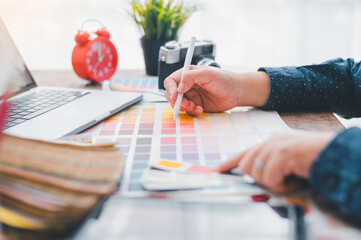 Fototapete - Graphic designer architects who work with laptops and color comparison tables for design work..