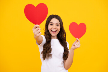 Poster - Lovely romantic teenage girl hold red heart symbol of love for valentines day isolated on yellow background. Happy teenager, positive and smiling emotions of teen girl.