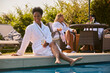 © Monkey Business - Mature Woman Wearing Robe Sitting With Feet In Pool Drinking Champagne On Spa Day