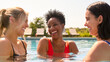 © Monkey Business - Three Mature Female Friends Wearing Swimsuits In Outdoor Pool On Spa Day