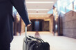 © Designpics - Businessman walking in the airport with suitcase