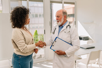 Wall Mural - a doctor shakes hands with her patient in consulting room