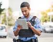 © JessicaLeigh J/peopleimages.com - Police, tablet and patrol with a man officer outdoor on the street, using the internet to search during an investigation. Technology, information or law enforcement with a male security guard on duty