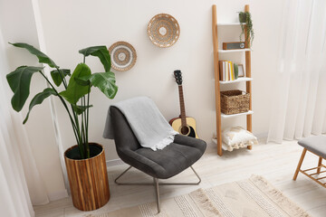 Poster - spring atmosphere. stylish room interior with comfortable chair, houseplant and shelving unit