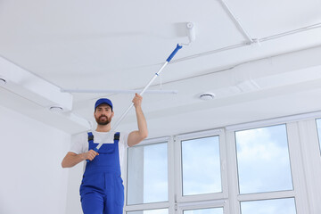 Sticker - Handyman painting ceiling with roller in room