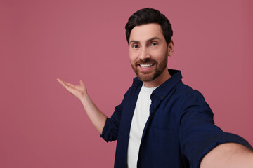 Canvas Print - Smiling man taking selfie on pink background, space for text