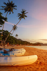 Summer seaside beach in evening There are kayaks and warm sunshine, perfect for a holiday getaway.		