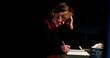 © Marco - Thoughtful senior person writing on paper at night older woman taking notes