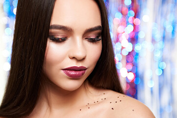 Wall Mural - Woman make-up with shiny glitter and snow on blurry background